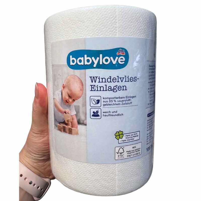 In Folie verpackte Rolle weiße Windelvlies-Einlagen von dm "Babylove". Die Infos sind in blauer Schrift gedruckt, ein spielendes Baby ist auf der Verpackung abgedruckt.